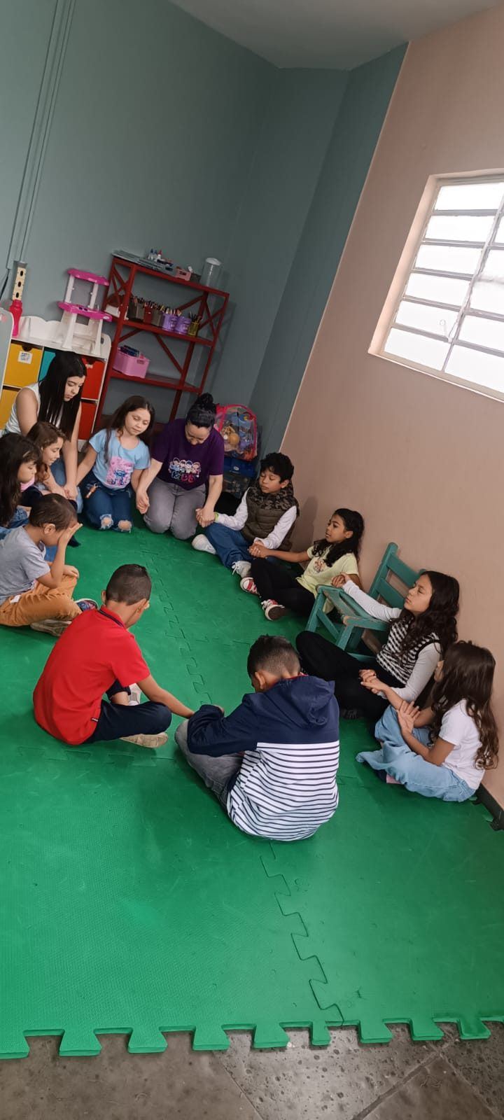 Crianças em roda orando de mãos dadas